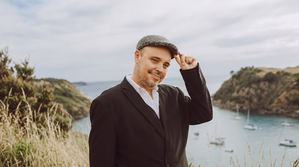 Aurélien Gillet, fondateur de Mana, souriant et ajustant sa casquette devant la mer