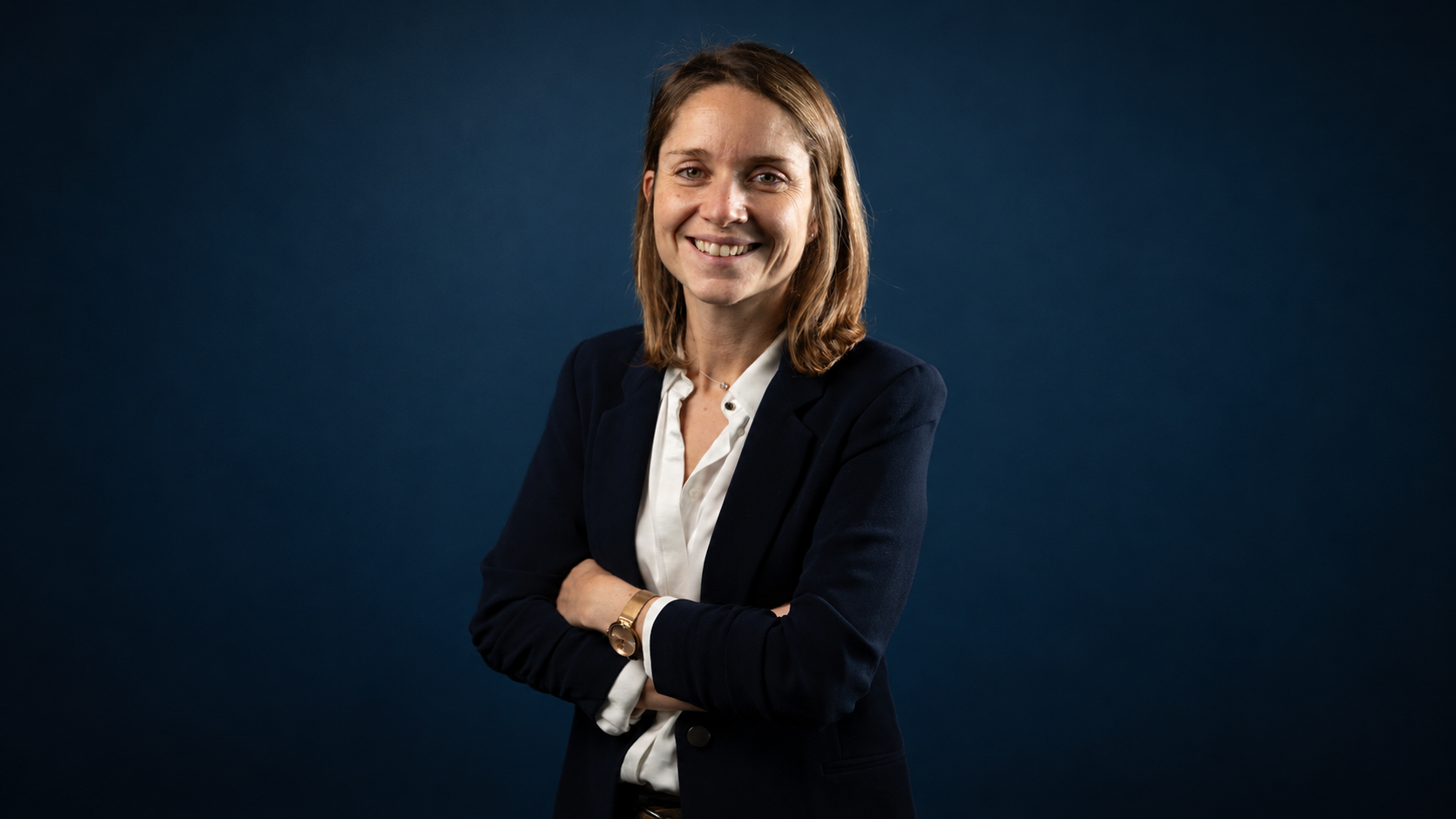 Portrait de Maëlle Delannée, directrice des ressources humaines et RSE de 4CAD Group, souriante et les bras croisés, en veste bleu marine sur fond bleu sombre. Elle signe une tribune sur l’attractivité des ETI industrielles, le recrutement des talents tech et les perspectives de carrière dans l’industrie.