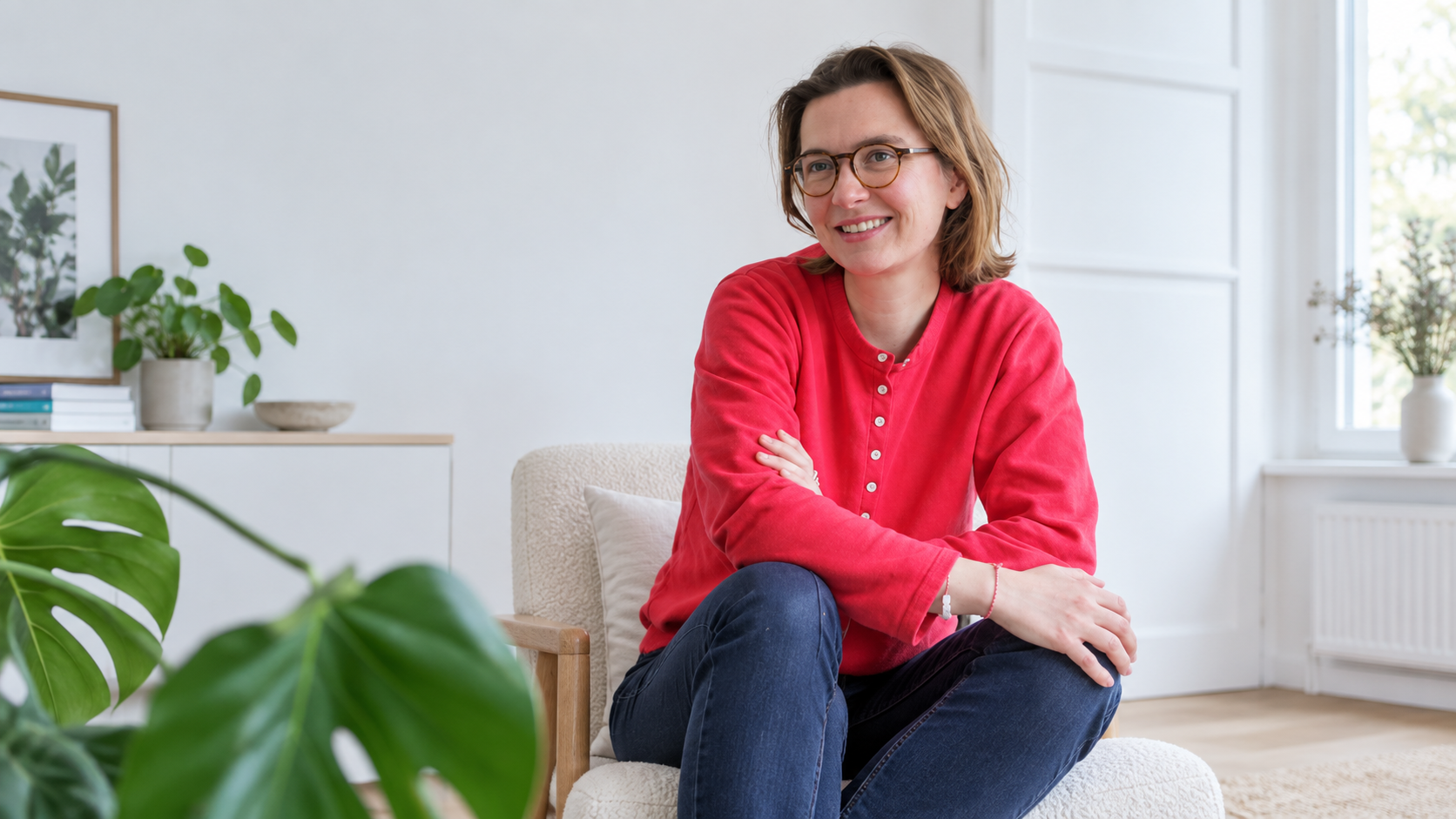 Portrait de Tara Heuzé-Sarmini en pull rouge et lunettes dans un bureau, illustrant l’affaire judiciaire liée à la publication d’un échange privé sur LinkedIn.