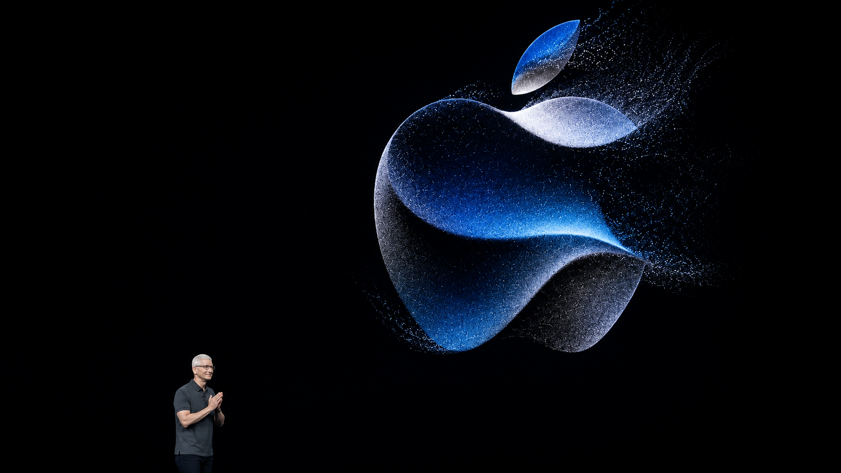 Logo Apple lumineux projeté sur une scène sombre lors d’une présentation technologique, avec un dirigeant en bas de l’image.