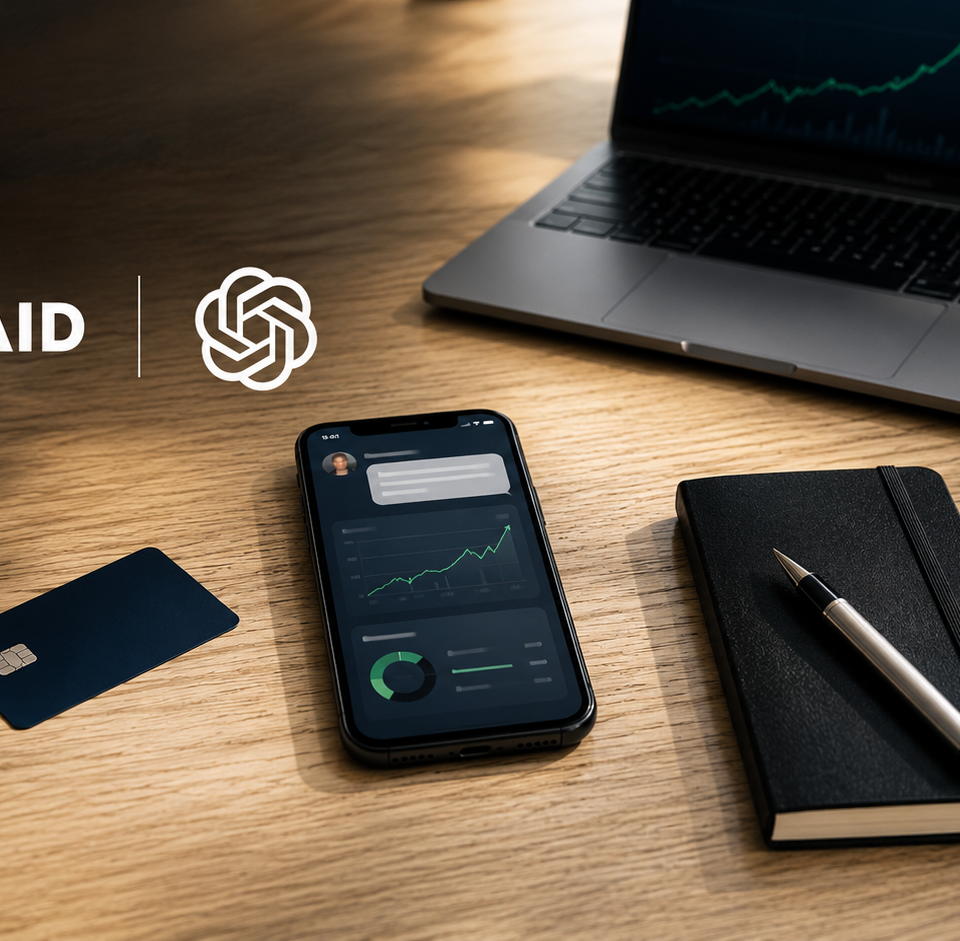 Vue de dessus d’un bureau professionnel minimaliste en bois clair avec smartphone affichant une interface IA financière, carte bancaire bleu profond, carnet noir et café, accompagné des logos Plaid et OpenAI. Ambiance fintech premium inspirée des médias économiques, lumière naturelle douce, ordinateur portable avec graphique boursier en arrière-plan flou, composition éditoriale moderne en format 16:9.
