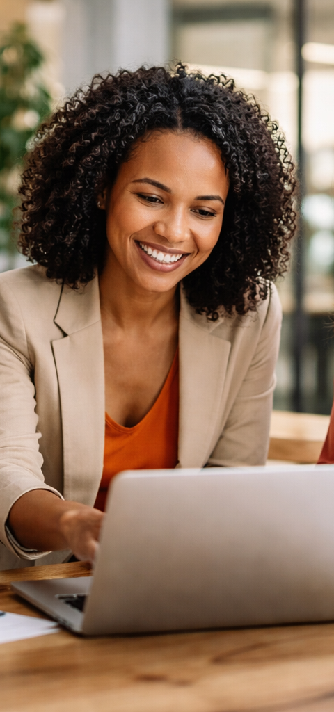 Trois femmes entrepreneures réunies autour d’un ordinateur dans un espace de travail moderne, échangeant sur le développement de leur entreprise.