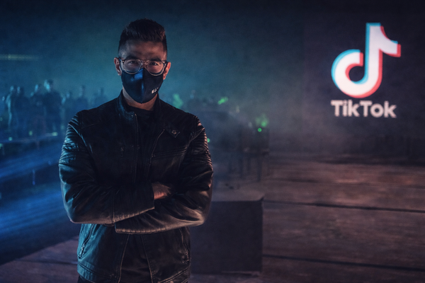 Visuel éditorial en format paysage montrant un dirigeant d’agence vêtu de noir, bras croisés, dans une ambiance sombre et bleutée, avec un logo TikTok en arrière-plan pour illustrer les zones grises de l’influence musicale.