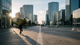 Une vue aérienne d'un quartier d'affaires moderne, avec des bureaux partiellement éclairés un vendredi après-midi, symbolisant l'impact du télétravail.